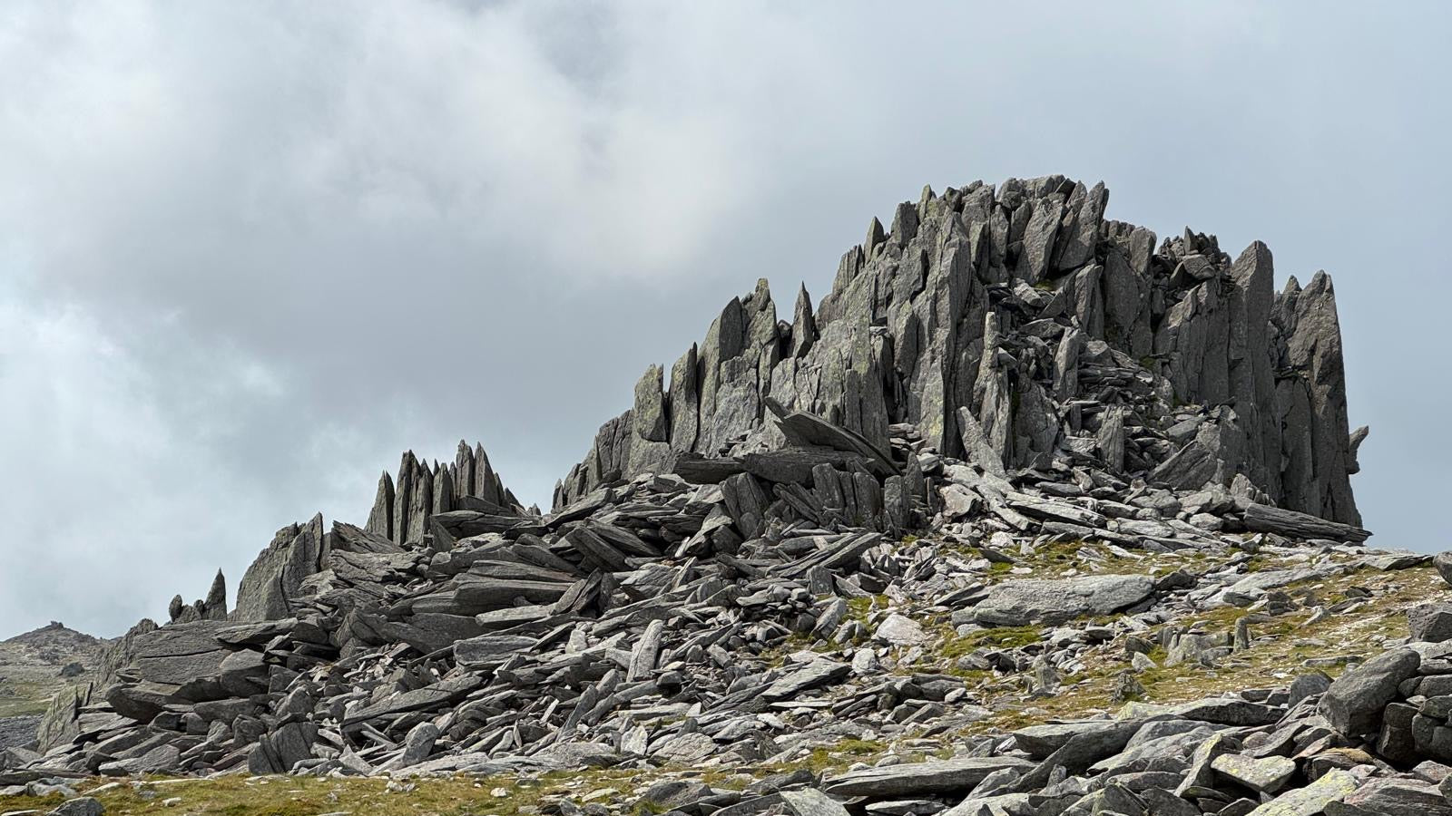 Rocky mountain peak with jagged rocks under a cloudy sky