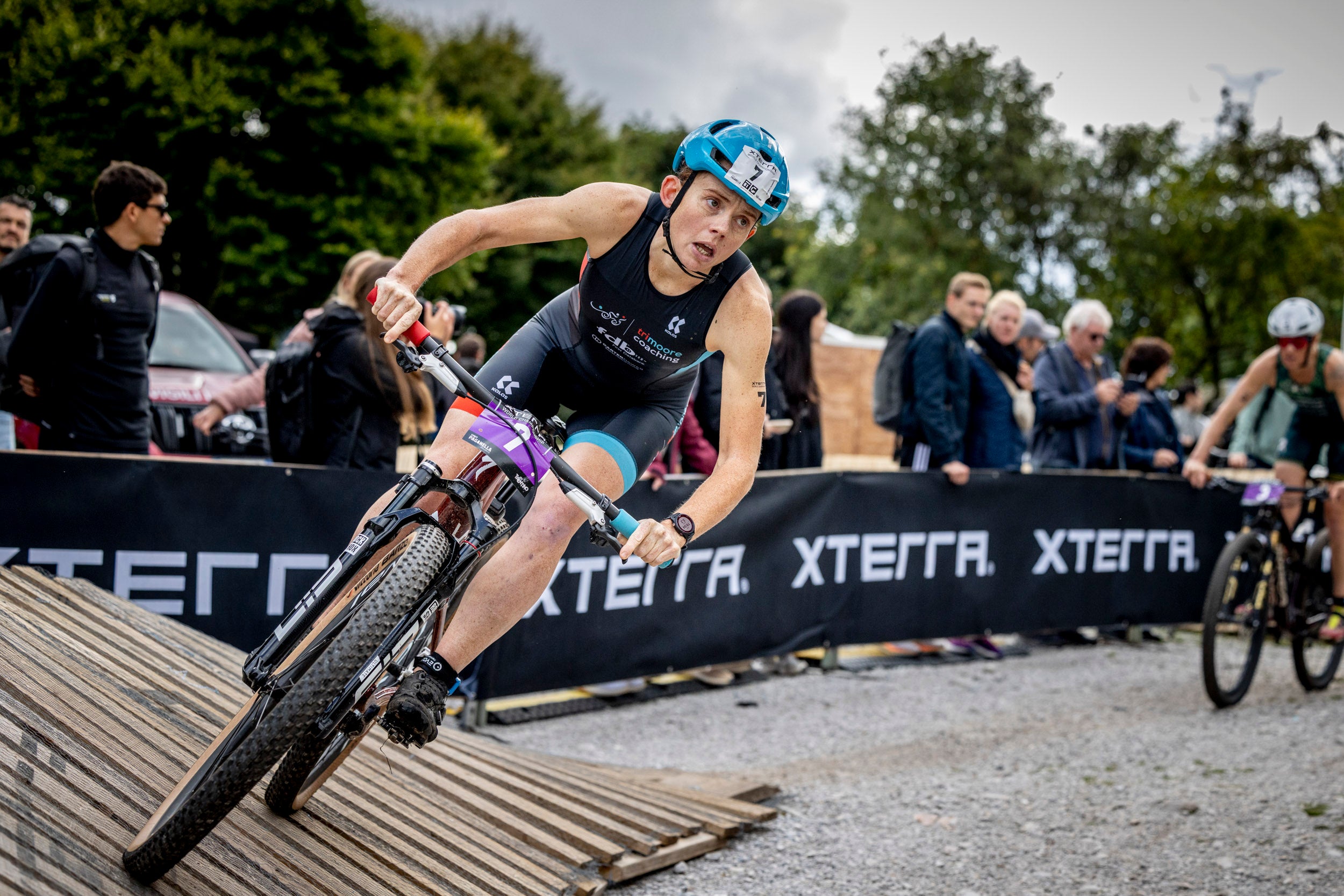 Athlete on a bike during a race with 'Xterra' branding in the background